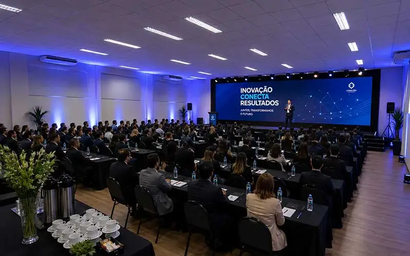 Sala do espaço Manacá montada para treinamento, com plateia em mesas